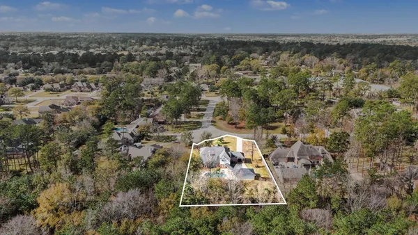 an aerial view of residential houses with outdoor space and trees