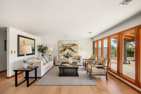 a dining room with furniture potted plants and wooden floor