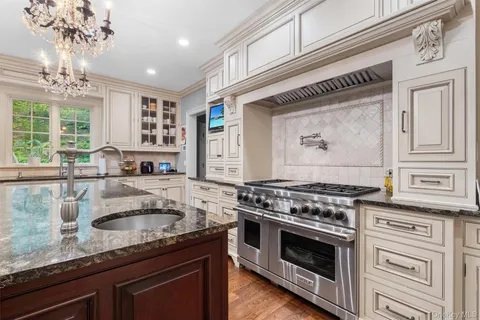 a kitchen with granite countertop a sink stove and cabinets