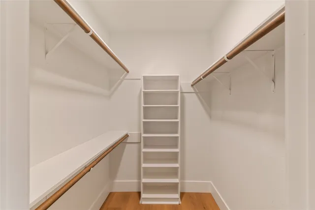 a view of walk in closet with empty racks