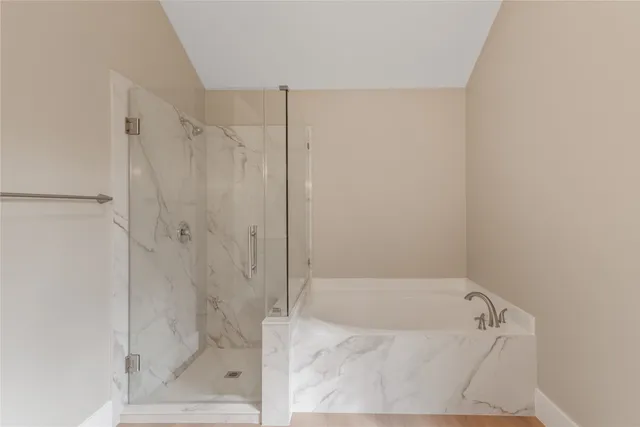 a bathroom with a tub shower and vanity