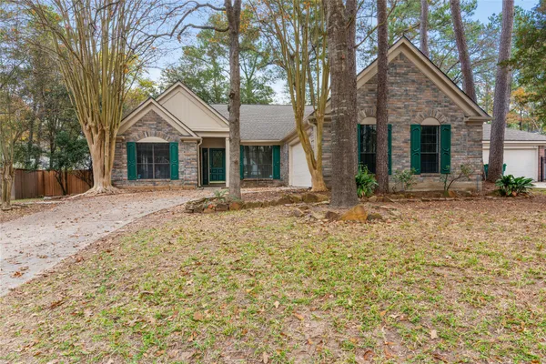 a front view of a house with a yard and trees