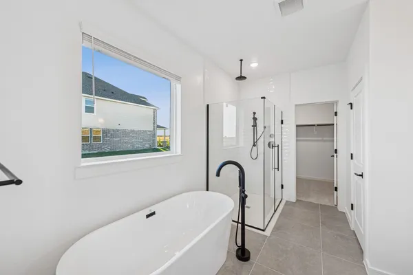 a bathroom with a bathtub a shower a sink and mirror