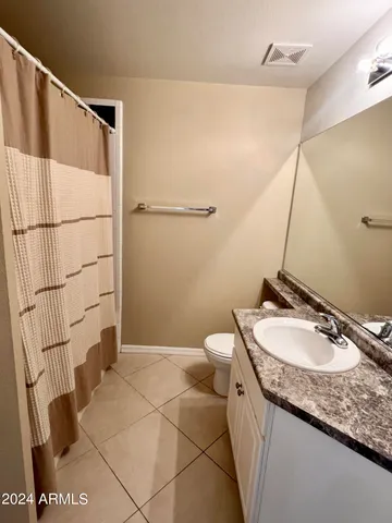 a bathroom with a granite countertop sink a mirror and a toilet