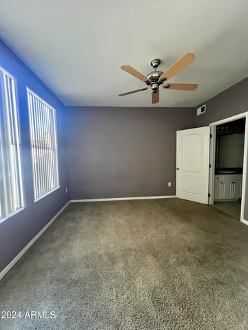 an empty room with windows and fan