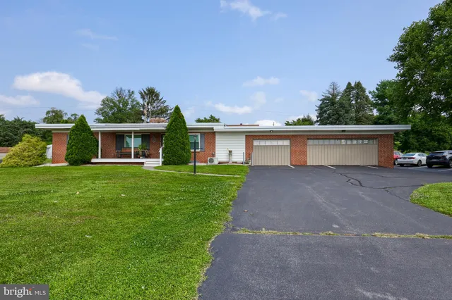 a view of a house with a yard and a garage