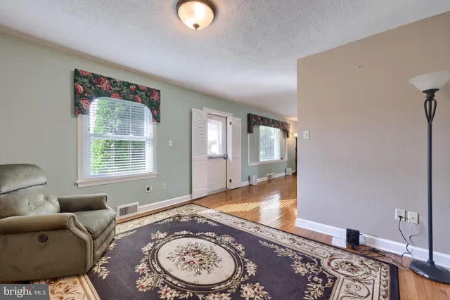 an empty room with wooden floor and a fireplace