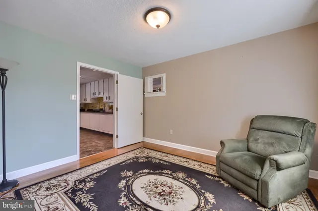 a view of an empty room with wooden floor and a fireplace