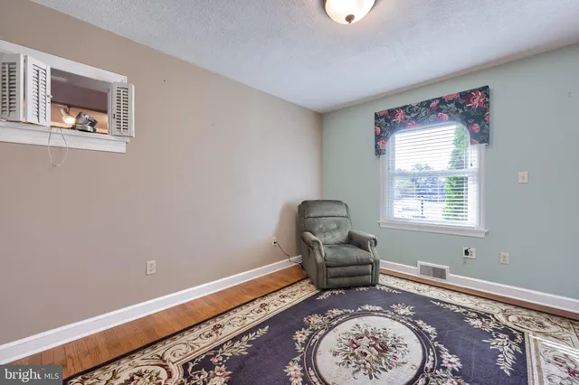 a view of empty room with wooden floor and fireplace