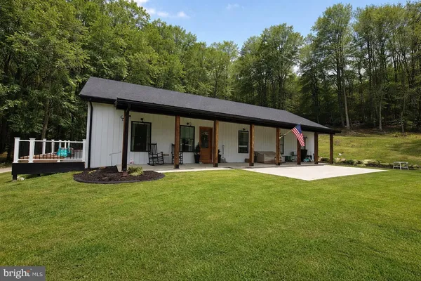 a view of a house with pool and chairs