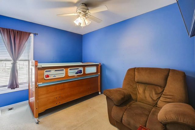 257 Bryant Way Bolingbrook, IL 60440 - Photo 13 of 20 a blue couch sitting in a living room next to a window