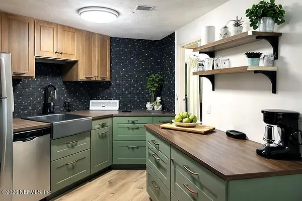 a kitchen with kitchen island a sink stainless steel appliances and cabinets