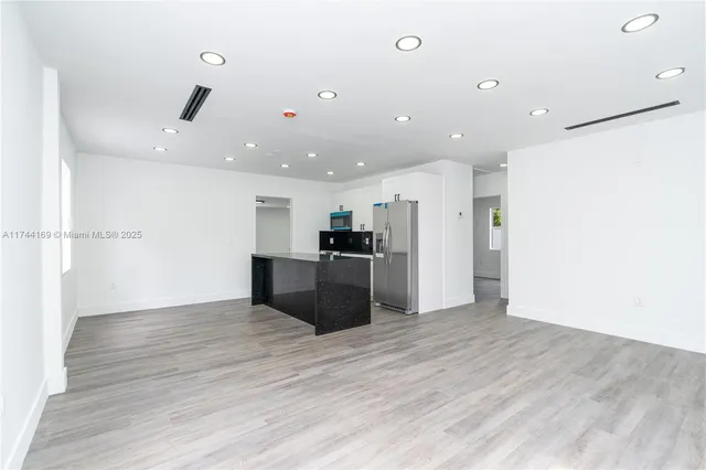 a view of kitchen with stainless steel appliances kitchen island a refrigerator sink and cabinets