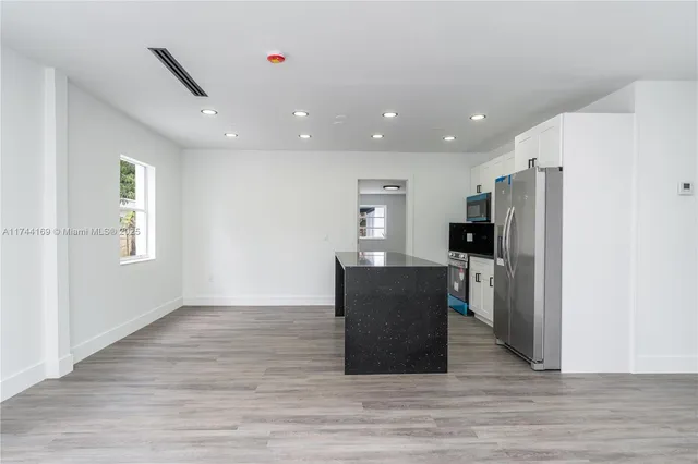 a view of kitchen with furniture and stainless steel appliances