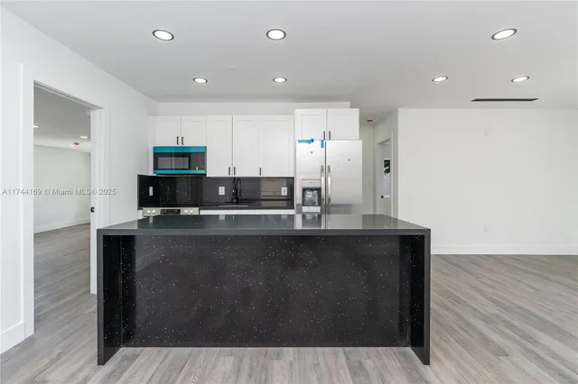 a kitchen with stainless steel appliances a sink a stove a refrigerator and cabinets