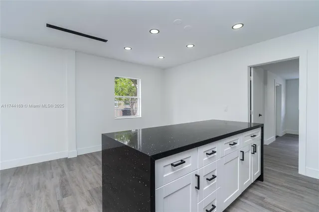 a kitchen with granite countertop cabinets and window