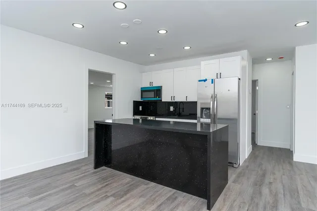 a kitchen with stainless steel appliances granite countertop a refrigerator and a sink