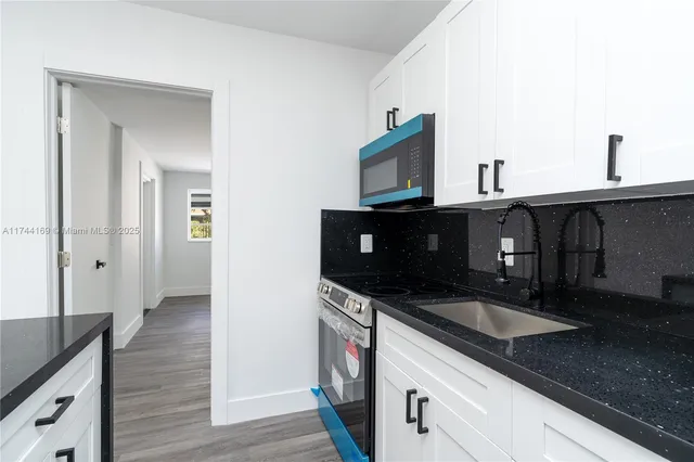 a kitchen with granite countertop a sink and a stove