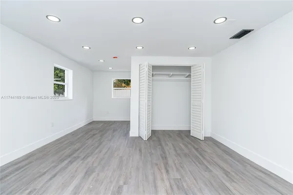 a view of a room that has wooden floor and window
