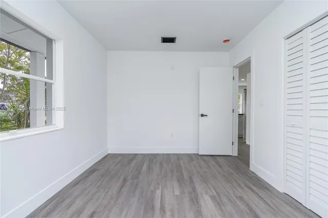 a view of a room with wooden floor and windows