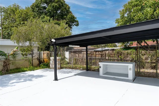 a view of backyard with large tree and wooden fence