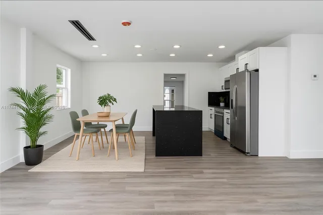 a view of a dining room with furniture and a refrigerator