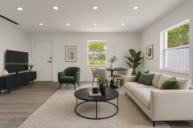 a living room with furniture a window and a flat screen tv