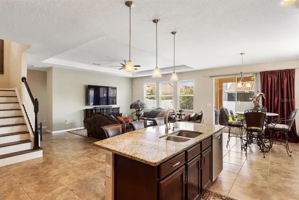 a open kitchen with stainless steel appliances kitchen island granite countertop a table chairs and a view of living room