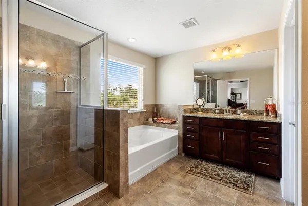 a spacious bathroom with a tub sink shower and mirror