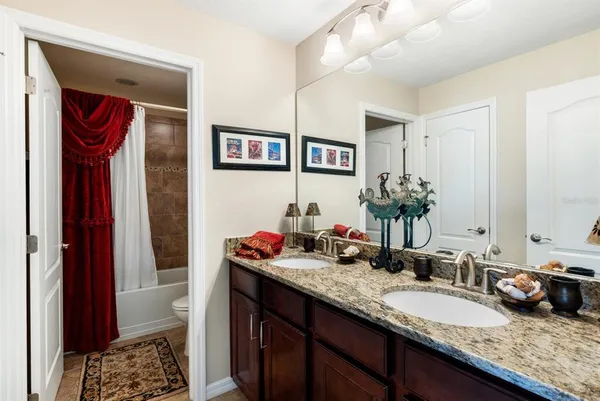 a bathroom with a granite countertop sink and a mirror