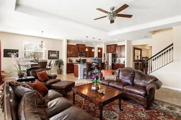 a living room with furniture kitchen view and a chandelier