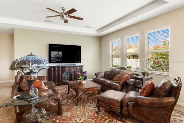 a living room with furniture a flat screen tv and a large window