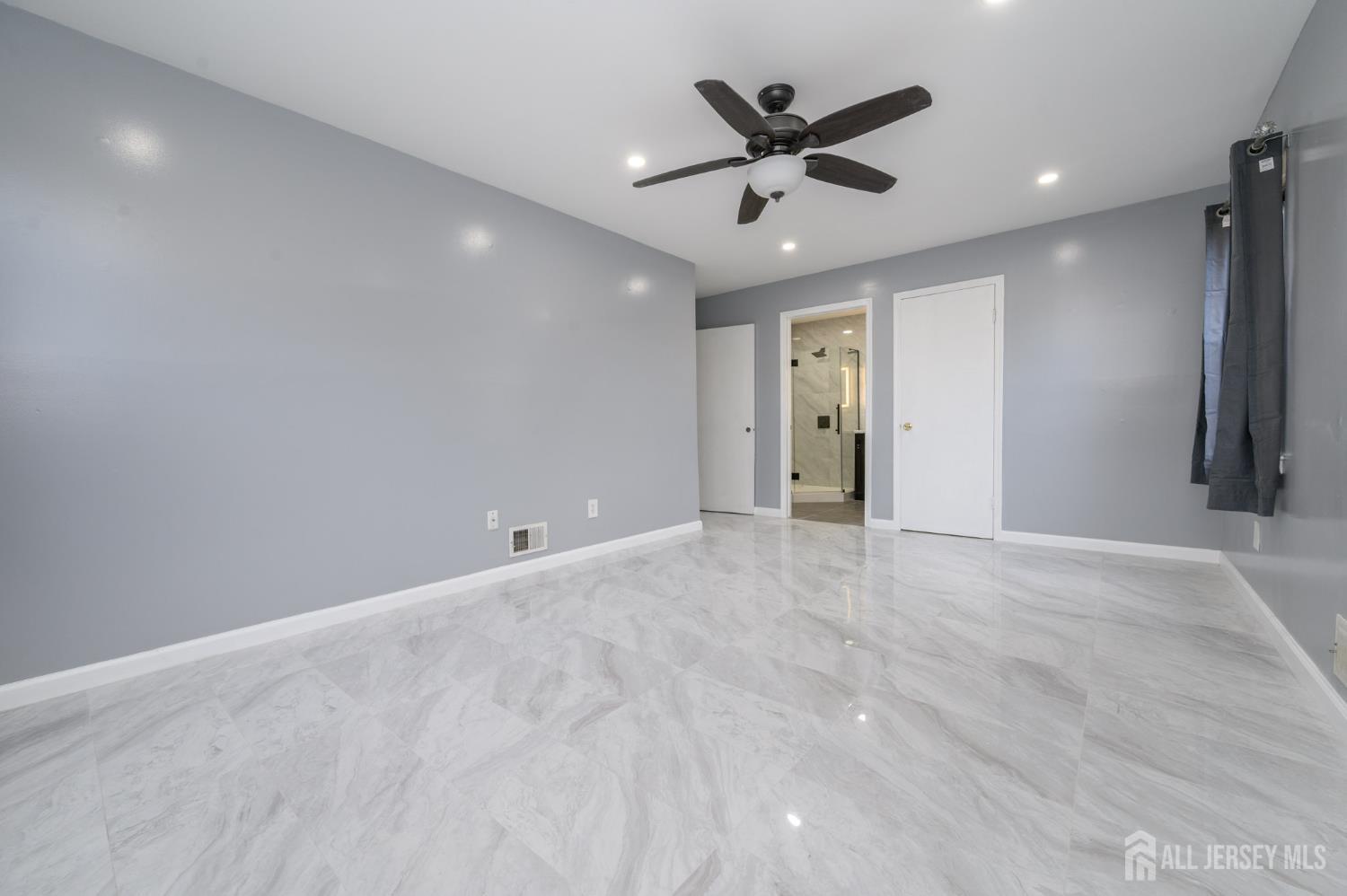 28 Powderhorn Court, Unit A Woodbridge, NJ 07095 - Photo 15 of 26 an empty room with ceiling fan and windows