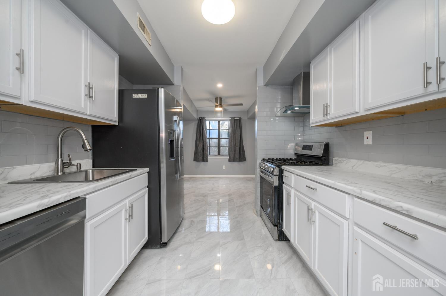 28 Powderhorn Court, Unit A Woodbridge, NJ 07095 - Photo 7 of 26 a kitchen with a sink stainless steel appliances and cabinets