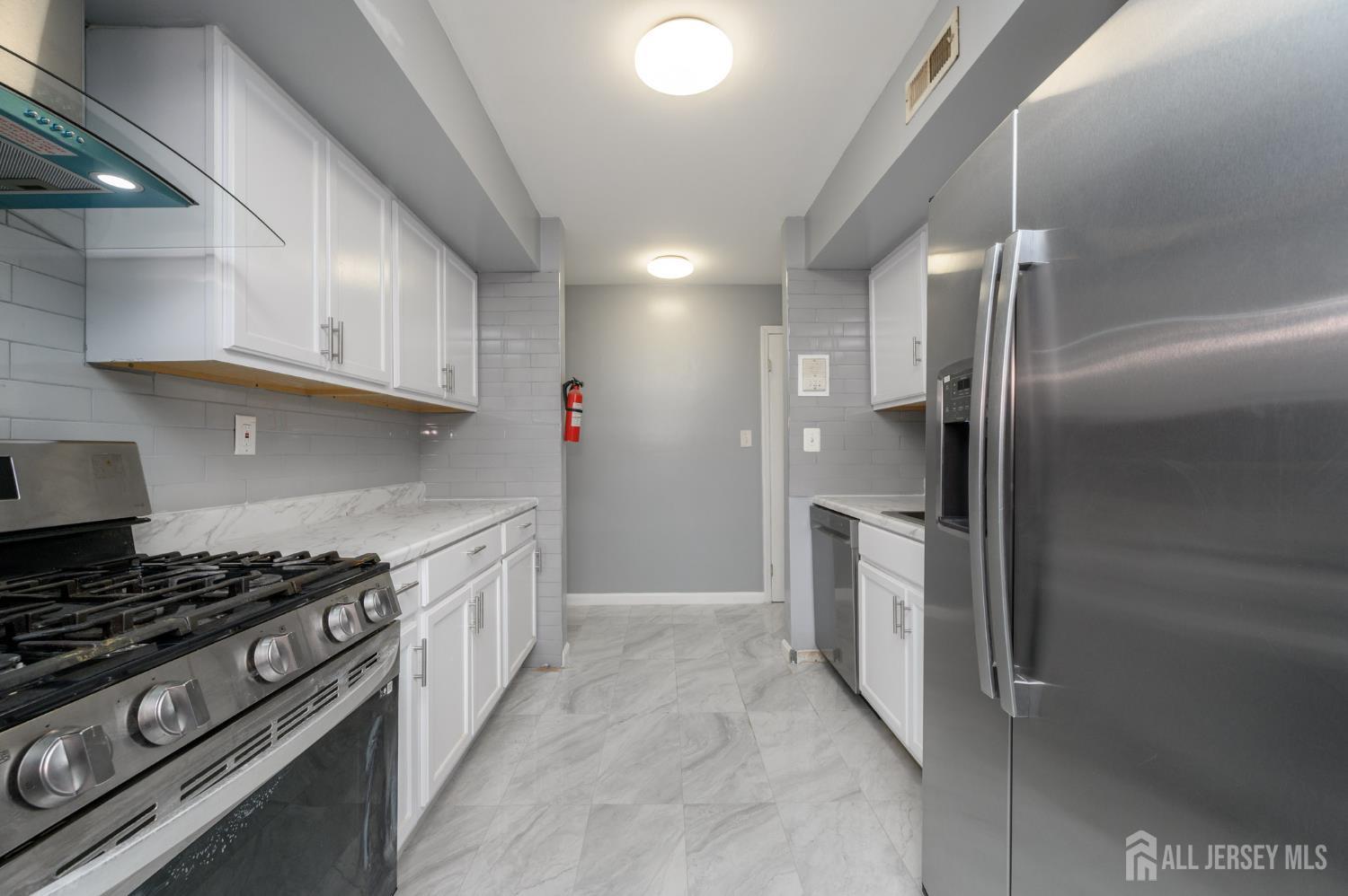 28 Powderhorn Court, Unit A Woodbridge, NJ 07095 - Photo 8 of 26 a kitchen with stainless steel appliances granite countertop a stove a sink and a refrigerator