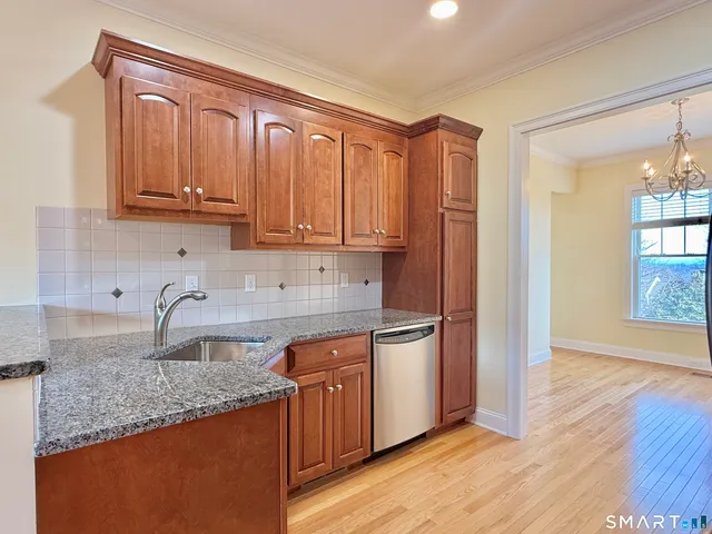 a kitchen with granite countertop a sink stove and cabinets