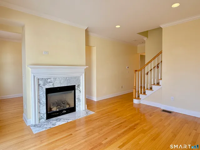 a living room with wooden floor and a fireplace