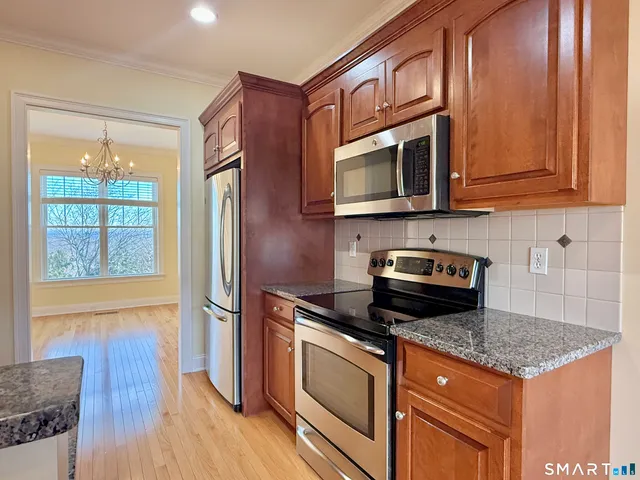 a kitchen with stainless steel appliances granite countertop a stove a sink and a microwave