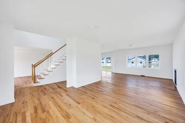 a view of empty room with wooden floor and window
