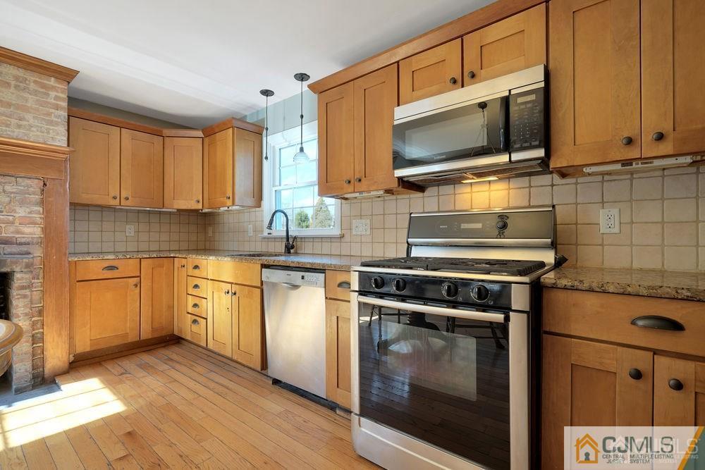 30 Old Post Road Edison, NJ 08817 - Photo 24 of 25 a kitchen with stainless steel appliances granite countertop a stove microwave and sink
