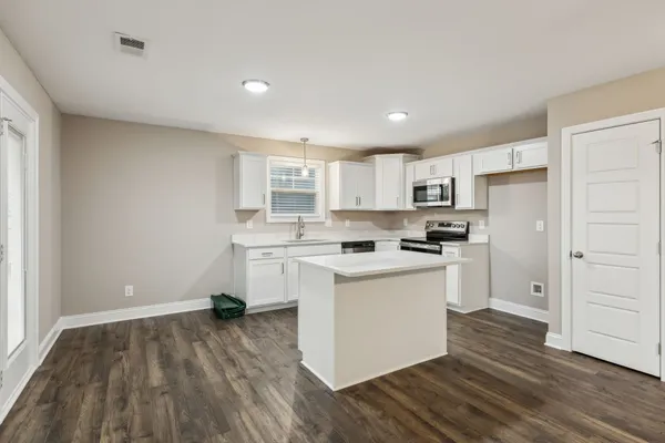 a kitchen with white cabinets and white appliances