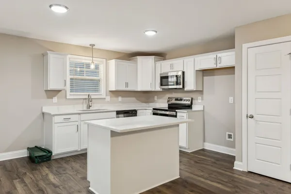 a kitchen with a sink stove top oven and refrigerator