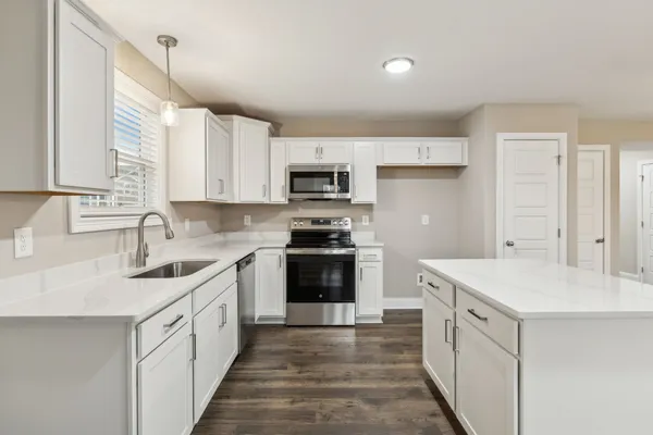 a kitchen with a sink stove and microwave