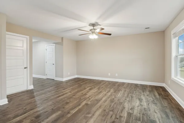 a view of a hallway with wooden floor and staircase