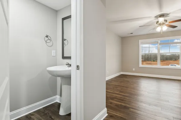 a view of an empty room and window with a ceiling fan