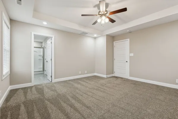 an empty room with closet and a ceiling fan