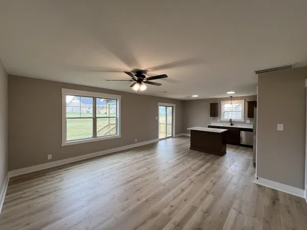 a view of an empty room and chandelier fan