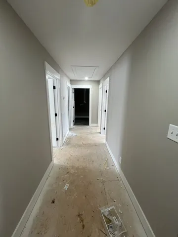 an empty room with windows and chandelier fan