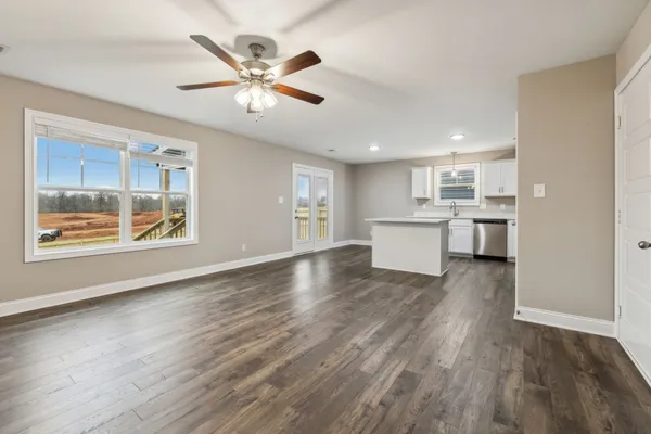 a view of a kitchen with wooden floor and a window