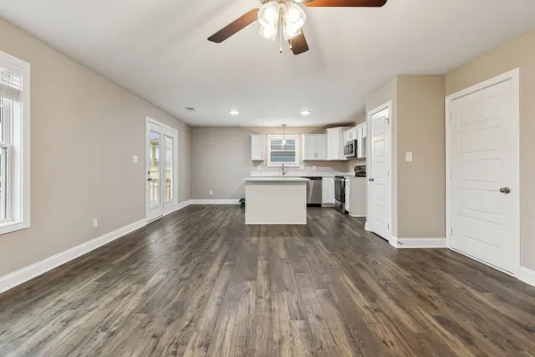 a kitchen with a sink stove cabinets and wooden floor